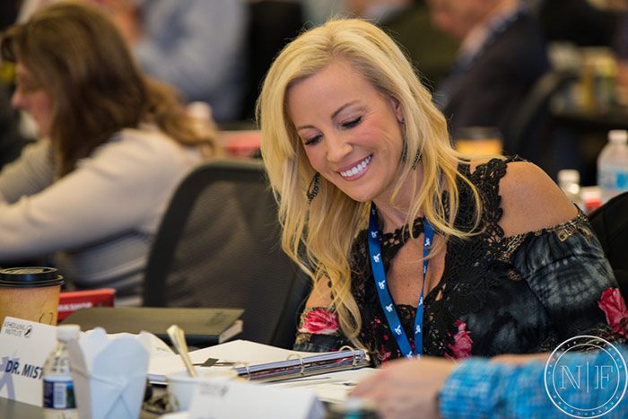 woman taking dentists notes at a conference